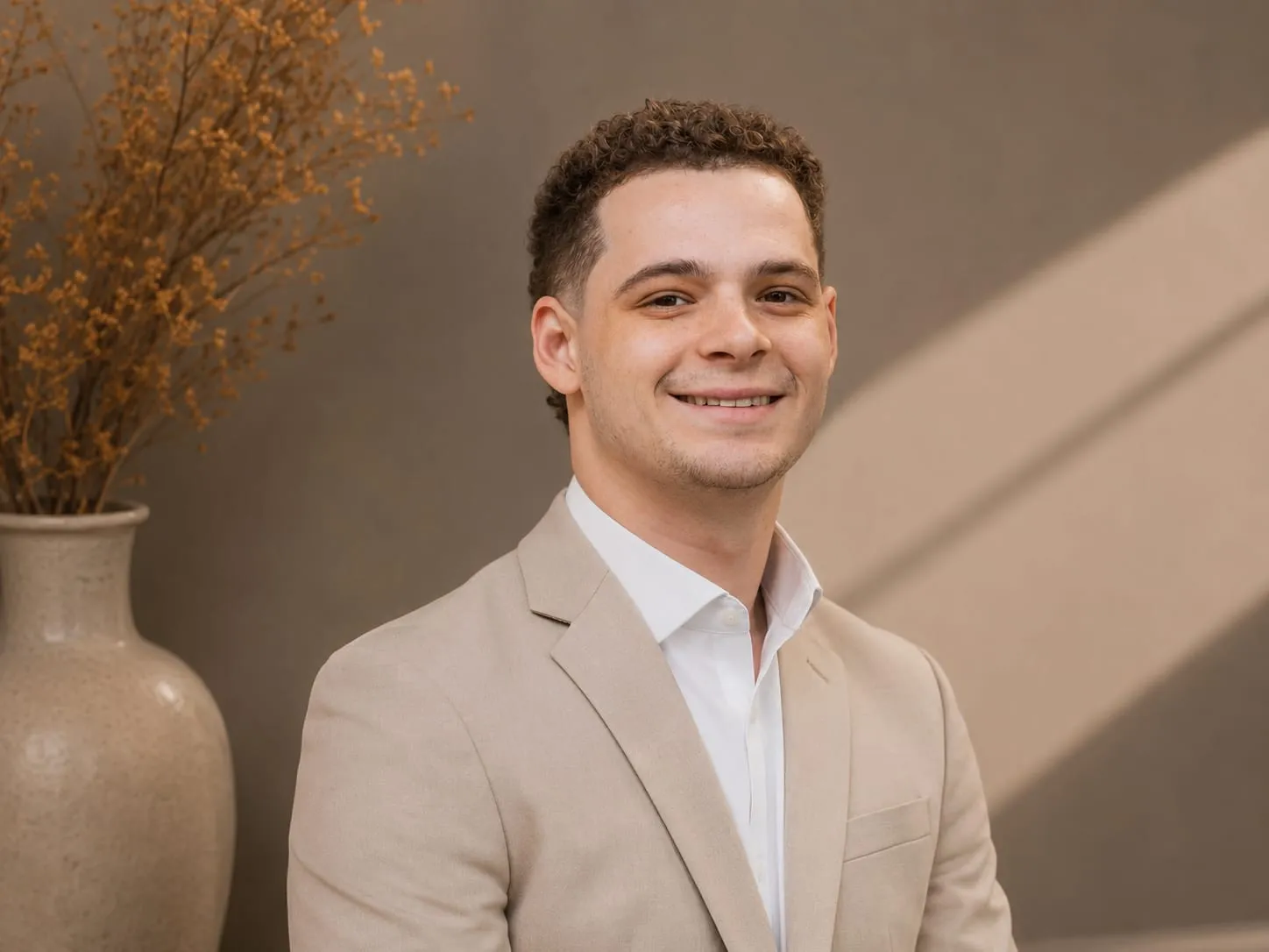 Tyler Stock, wedding DJ and MC, smiling in a tan blazer